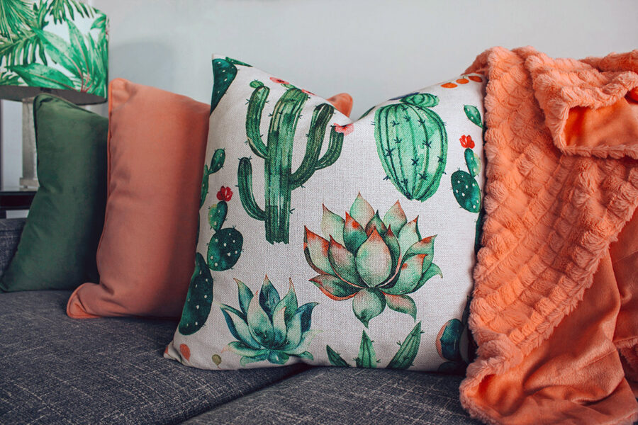 Three cushions and a blanket on a sofa 