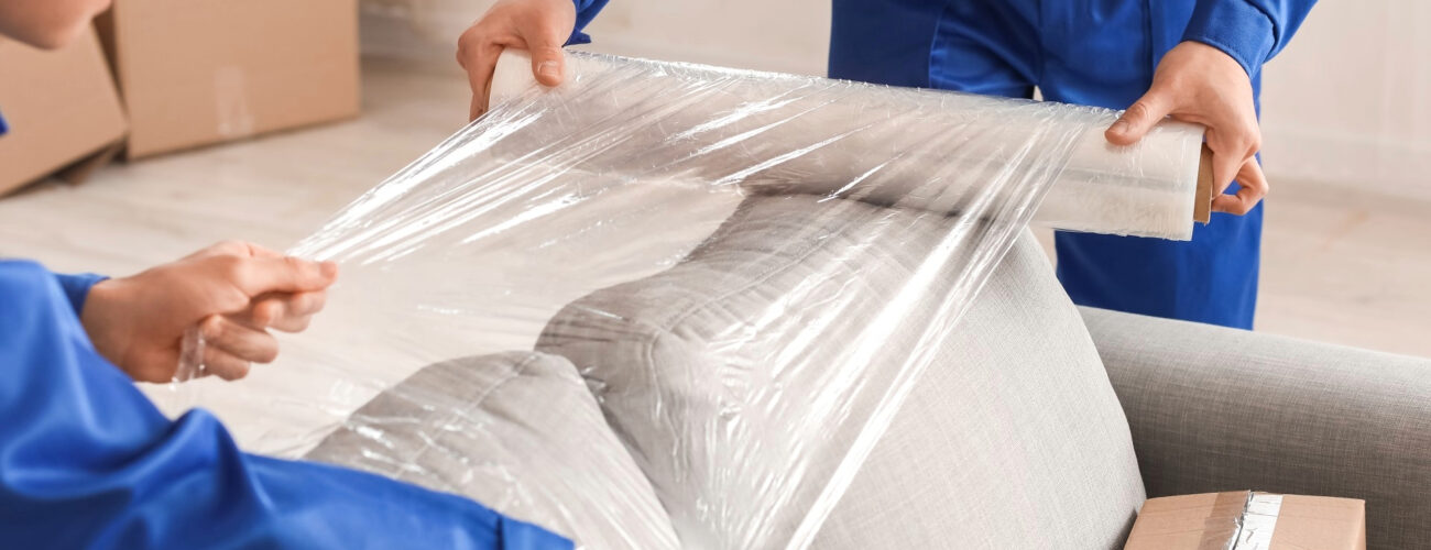 Movers wrapping and protecting furniture