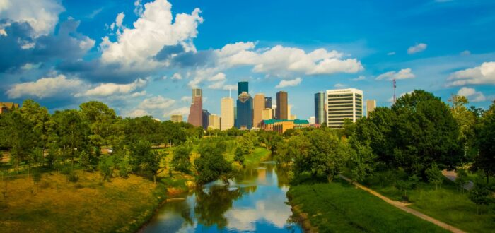 Green trees and calm water under a blue sky in Houston.